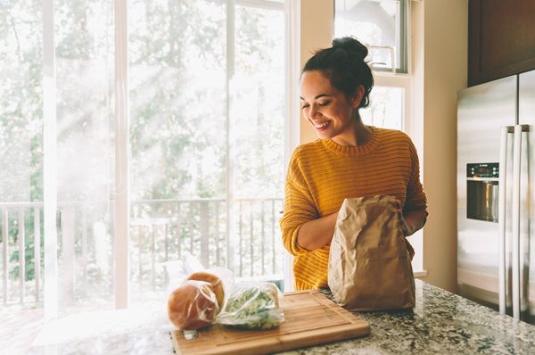 Woman in yellow sweater smiling,  excited to make recipes