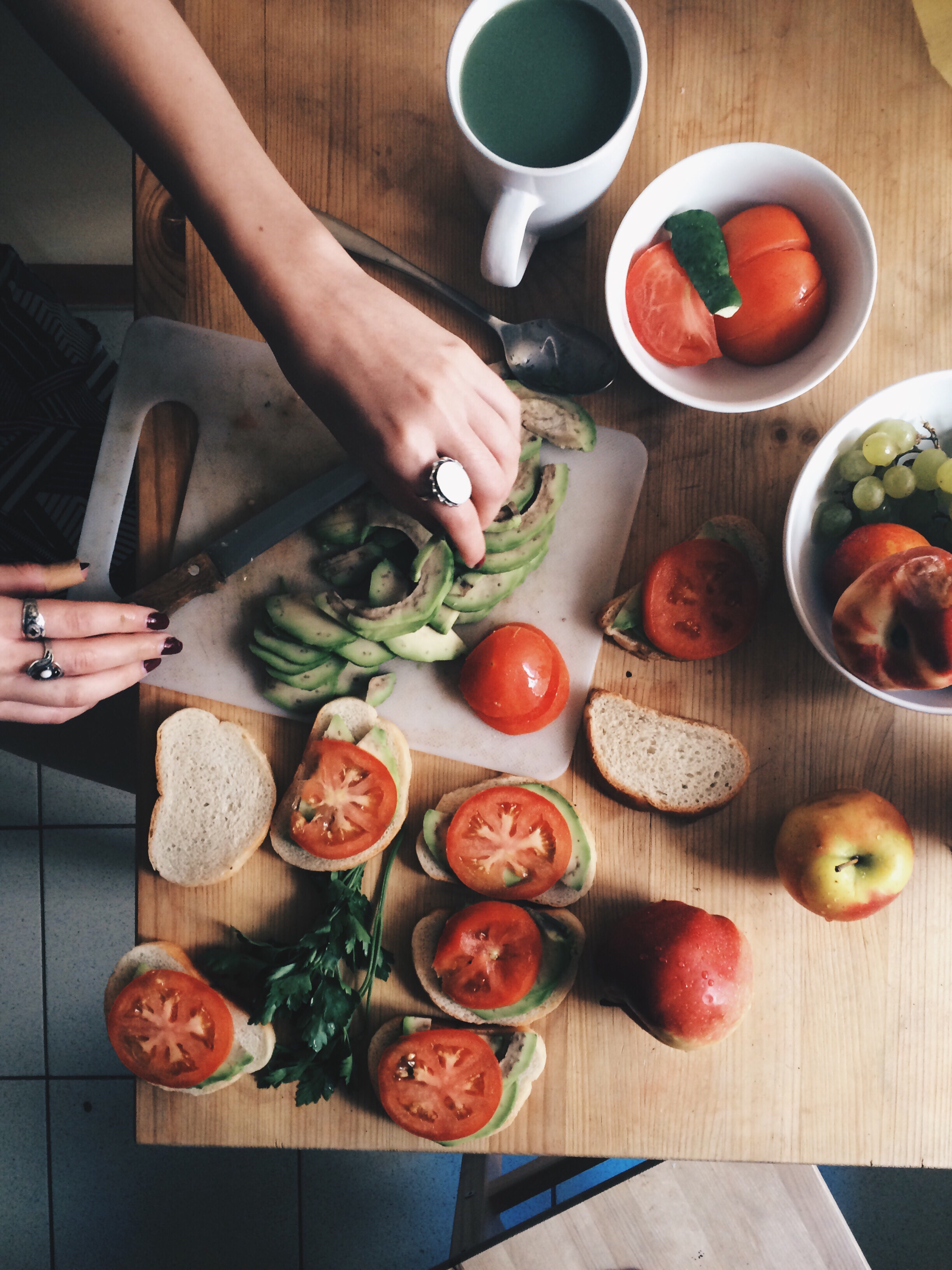 Person slicing avacados on cutting board making a healthy recipe for sandwiches