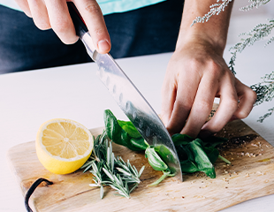 FoodCombining_WebImage-(1).png Woman's hand chopping fresh herbs on cutting board with fresh lemon