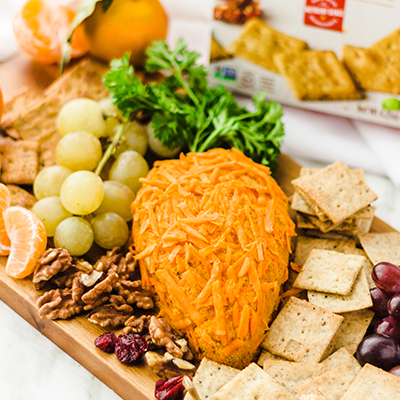 Charcuterie consisting of grapes, nuts, vegan Carrot Cheese dip and Simple Mills almond flour crackers