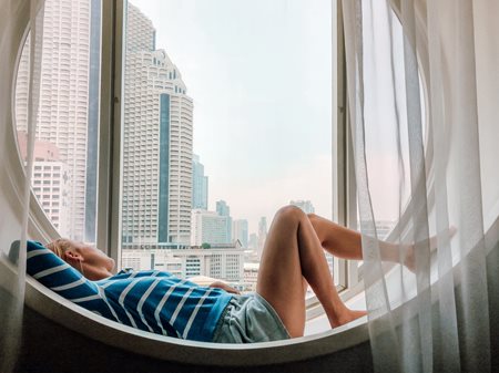 Woman lounging in front of window overlooking city views