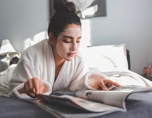 Woman with a face mask on reading a magazing practicing-self care